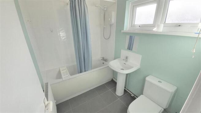 Bright bathroom with bathtub and sleek tiling...