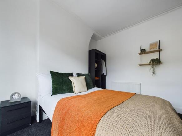 A bright and inviting double bedroom with styli...