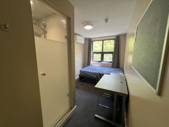 Neat single bedroom with a study desk, comforta...