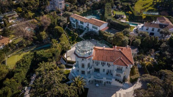 Aerial view of a large, elegant villa with a red-t