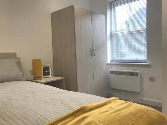 Bright bedroom with stylish wood-finish wardrob...