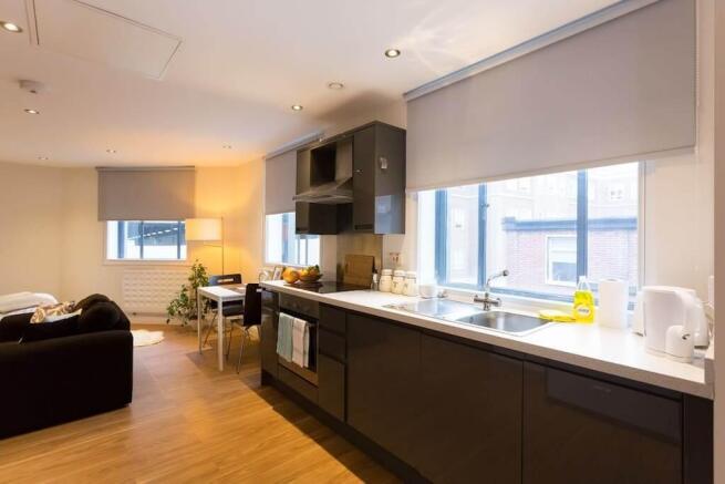 Modern open-plan kitchen with sleek dark units...