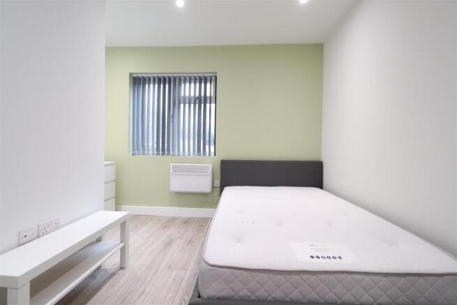 Bright, simply furnished bedroom with a comfort...