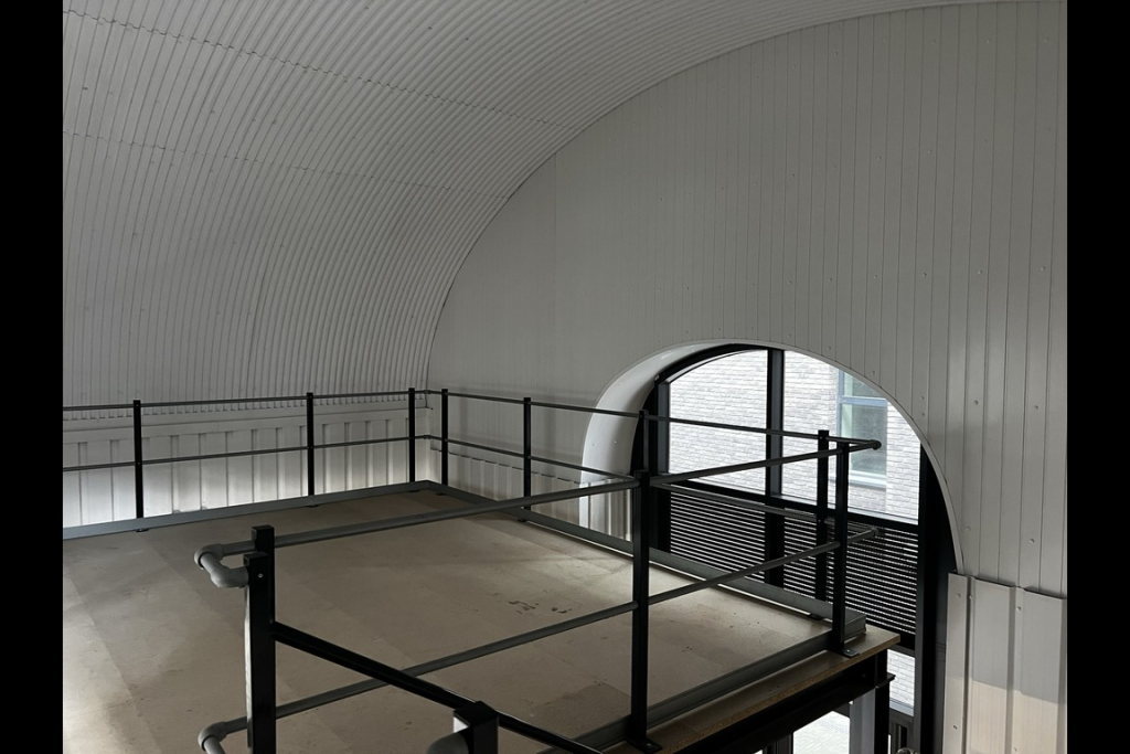 The mezzanine level of an arch, with carpet and lined white.