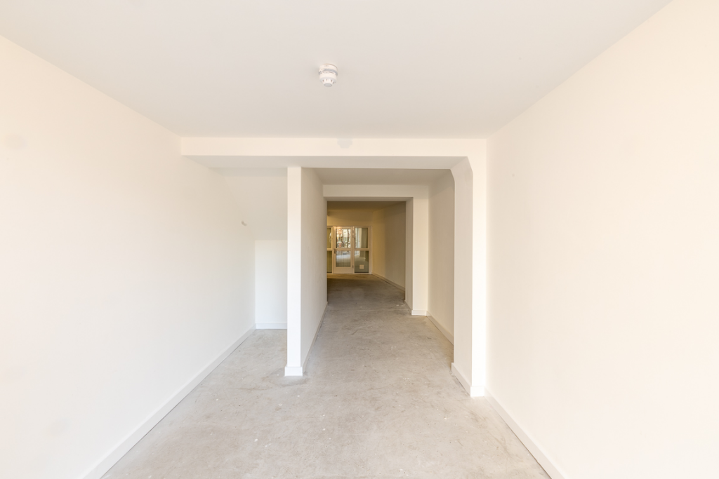 An empty arch with lining and full height glazing to the front