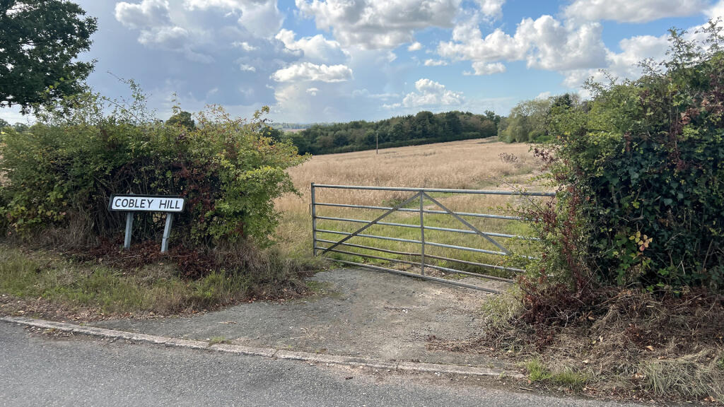 Road frontage and gated entrance to the north.