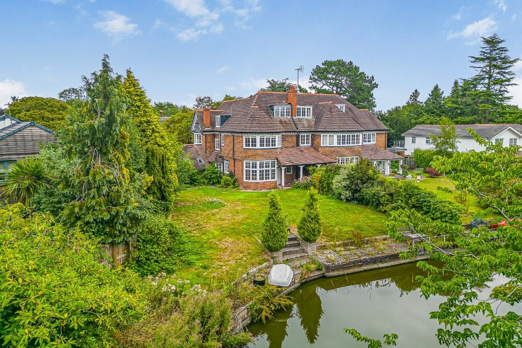 Main image of property: Curzon Park North home with private mere frontage, refined interiors, gym, sauna and a south-facing garden retreat.