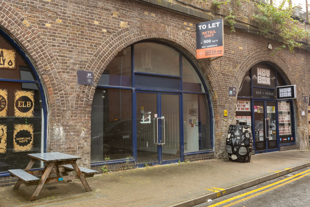 The front of an arch, with a fully glazed frontage and door allowing you to see into the arch interior.