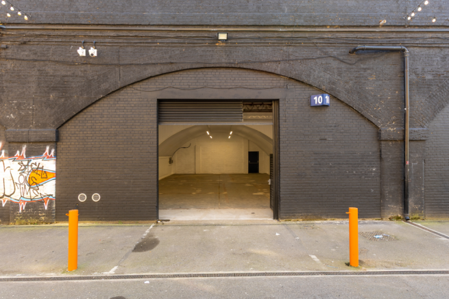 The front of an arch with an open electric roller shutter entrance big enough for vehicle access, and separate pedestrian door.