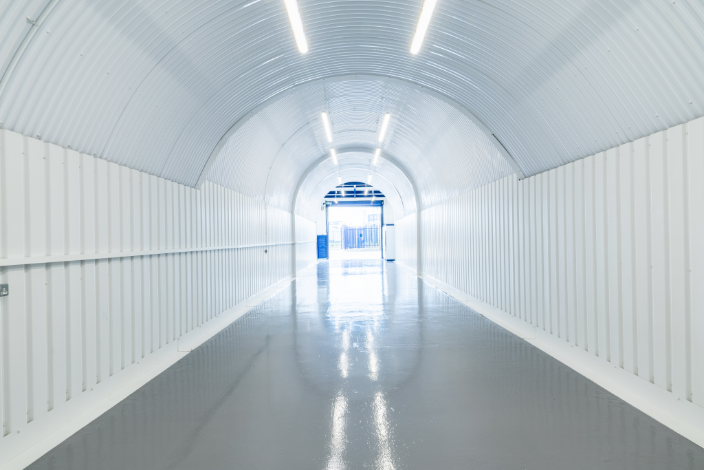 An empty arch with white lining and full height glazing to the front.