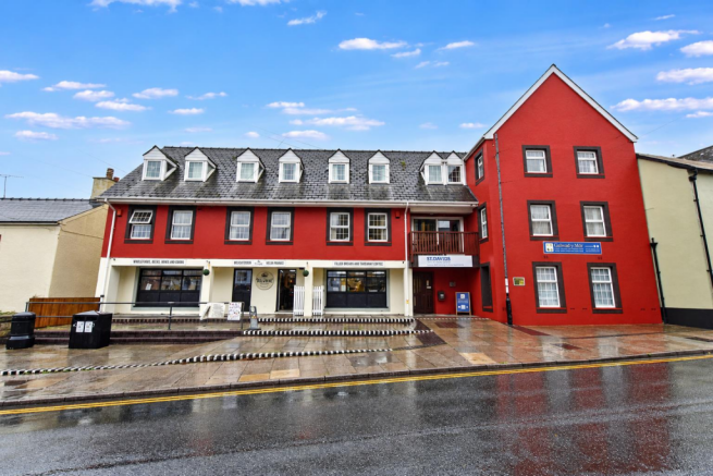 Rainy Street View of Coastal Delicatessen Building