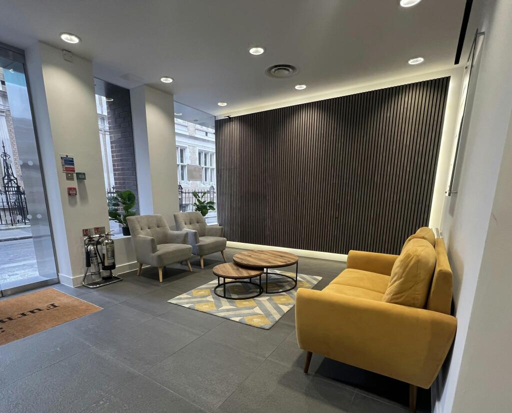 30-31 Furnival Modern Lobby With Seating And Decorative Wall Panel.jpg