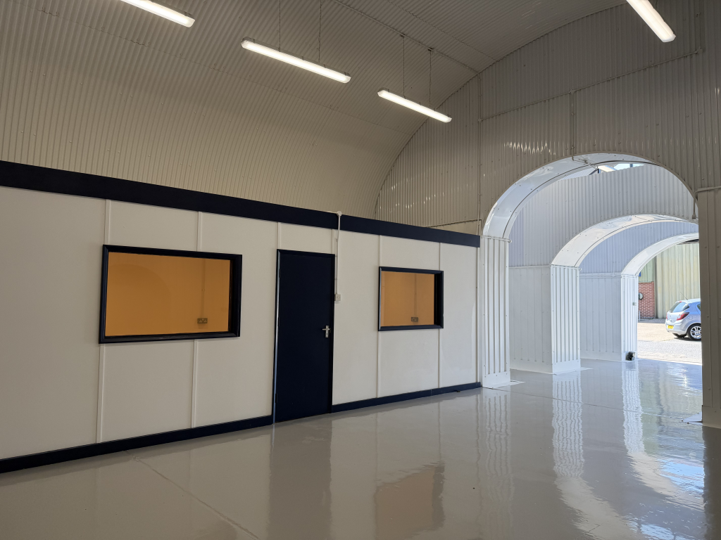 An empty arch with white lining and a WC cubicle to the front.