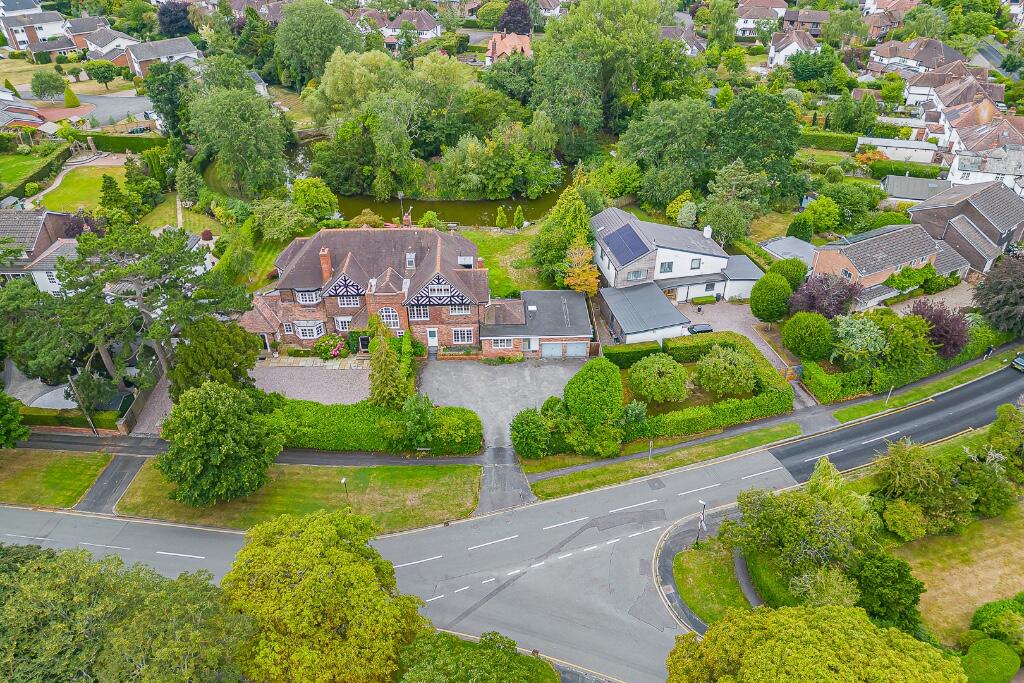 Main image of property: Curzon Park North home with private mere frontage, refined interiors, gym, sauna and a south-facing garden retreat.
