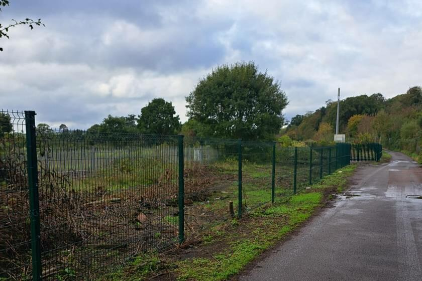 A large plot of land, with metal fencing around it.