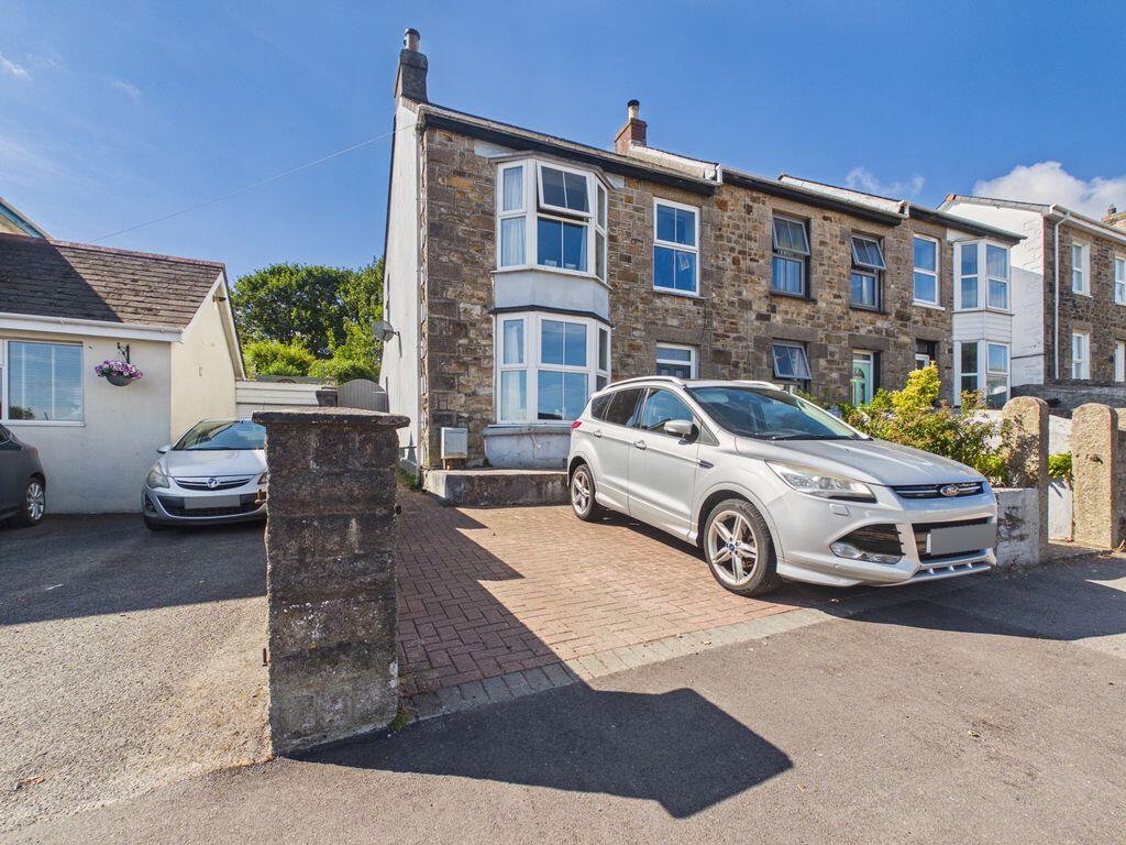 Main image of property: Illogan Highway - Bay fronted end terrace house, three bedrooms, first floor bathroom, parking and gardens