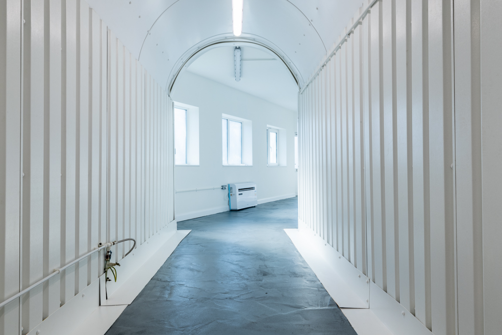 An empty arch with lining, and an office unit at the back.