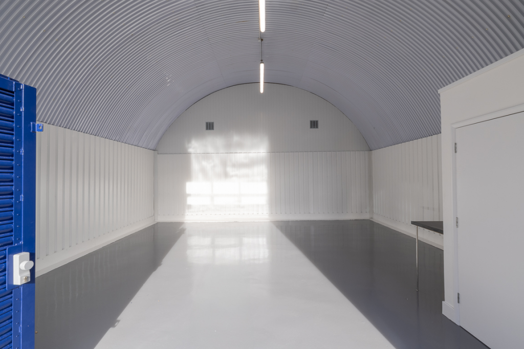 An empty arch with white lining and a WC cubicle to the front.
