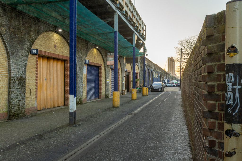 An estate, with multiple arches next to each other. The arches have closed electric roller shutter entrances.