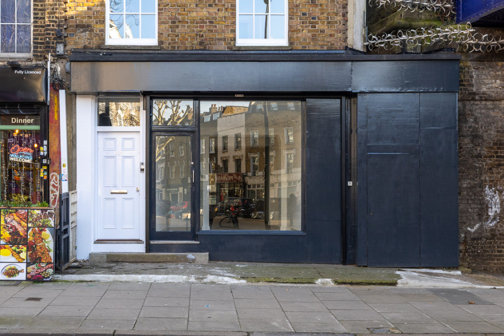 The front of an arch, with a fully glazed frontage and door allowing you to see into the arch interior.