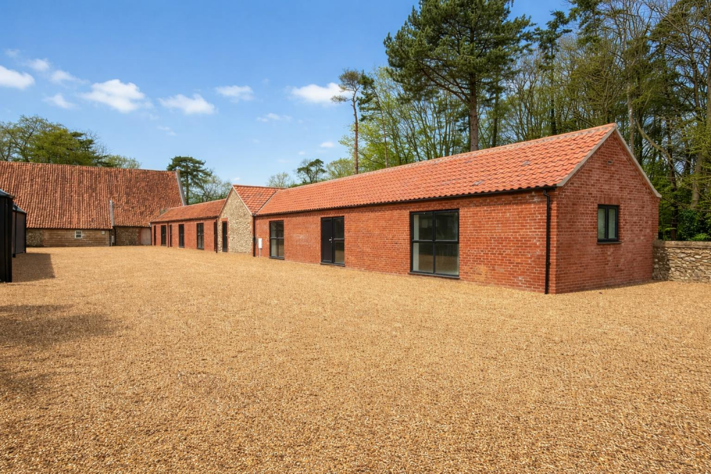 Charming barn row under bright skies.png
