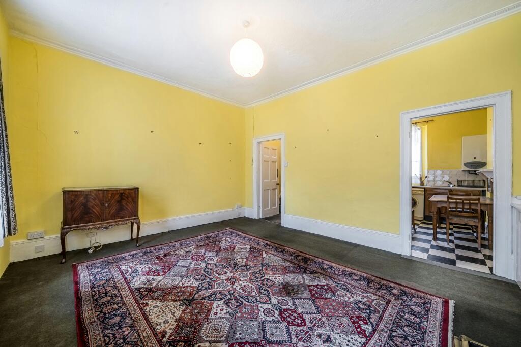 255 Grays Inn Road Bright Yellow Room With An Ornate Rug.jpg