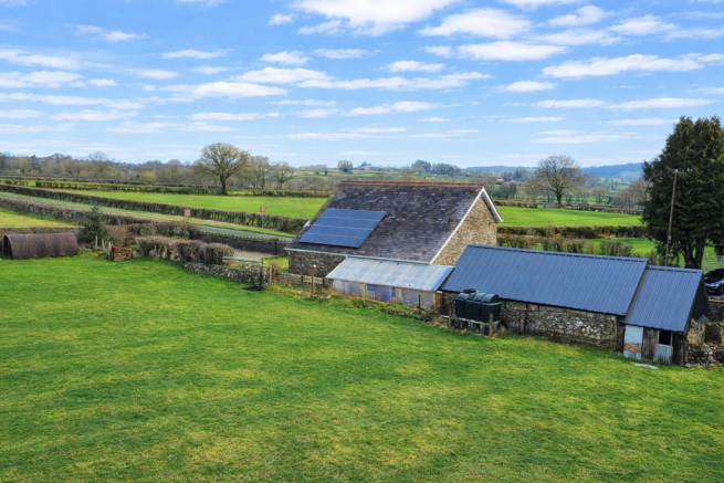 Rural scene with stone buildings and fields.png
