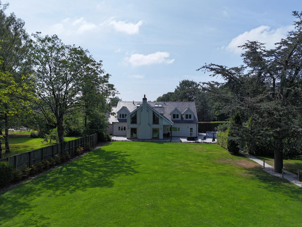 Main image of property: Detached home with a quadruple garage and annex, set in 1.5 acres of private and mature grounds