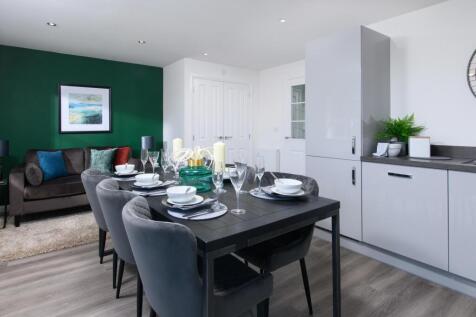 Open-plan kitchen/diner with integrated appliances and French doors leading onto garden in Ingleby s