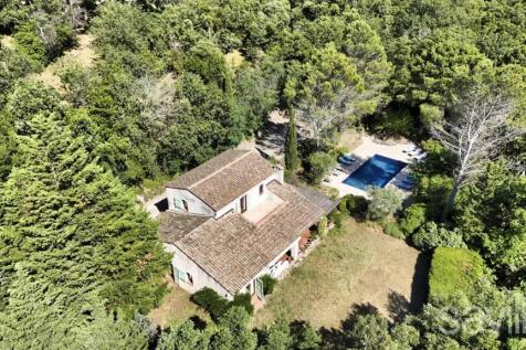 Aerial view of a rustic house surrounded by greene