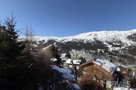 A snowy mountain landscape with rustic wooden hous