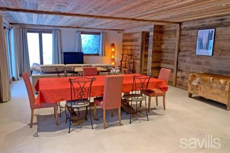 A spacious, rustic dining room features a wooden t