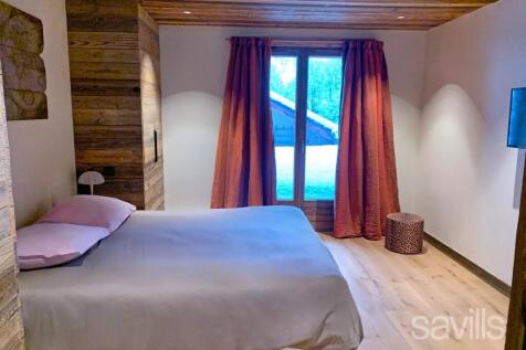 This image shows a cozy bedroom with wooden walls 