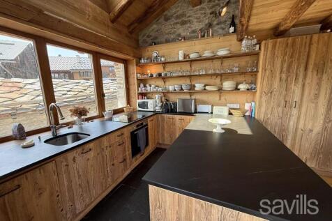 A cozy, rustic kitchen with wooden cabinets, open 