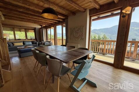 A rustic dining and living area with wooden beams 