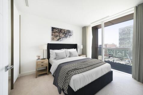 Experience the serenity of urban living in this elegantly designed bedroom with a breathtaking city view.