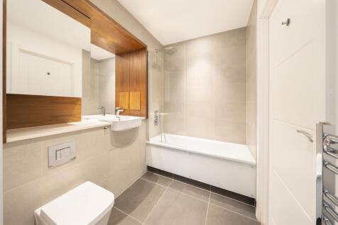 Indulge in modern luxury with this elegant bathroom design, featuring stylish finishes and wood details.
