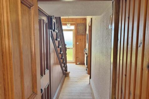 Entrance hallway stairs to front door from kitchen