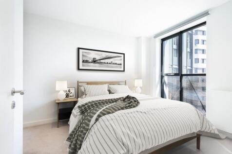 Experience urban tranquility in this stylish bedroom, featuring natural light and sleek design.