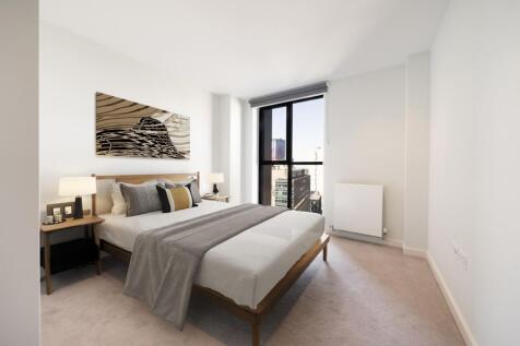 Experience relaxation in this elegant bedroom with stunning cityscape views.