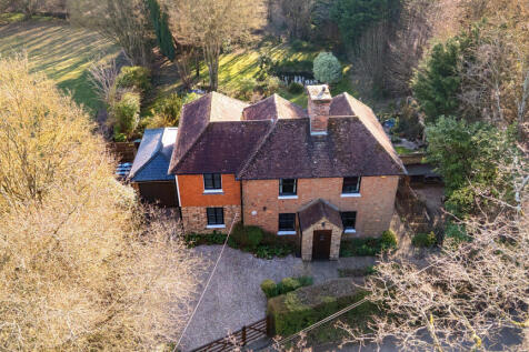 Front elevation, driveway with parking for three vehicles, private rear garden and private woodland