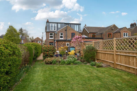 Rear elevation and large shrub and flower border with rear terrace and decking beyond