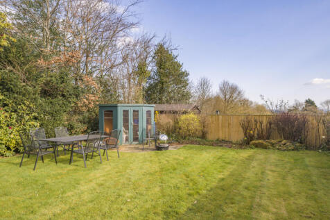 South facing rear garden with an array of mature trees, shrubs and fruit trees as well as large lawned area