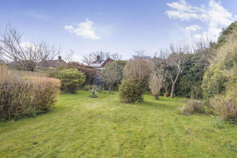 South facing rear garden with an array of mature trees, shrubs and fruit trees as well as large lawned area