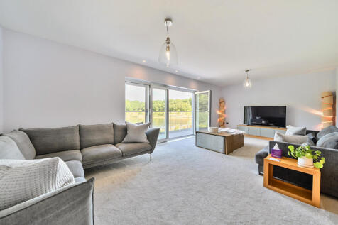 Living Room with bi-fold doors opening out onto balcony with views over the lake