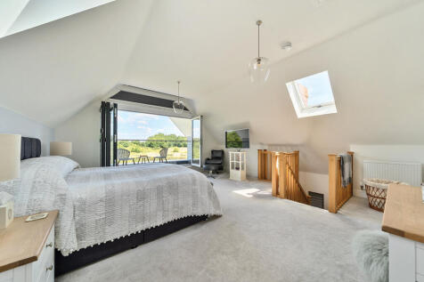 Master Bedroom with vaulted ceiling and bi-fold doors opening out onto balcony with stunning views over the lake