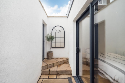 Outside stepped area with olive tree and mirror.pn