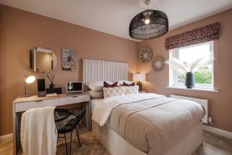 Double bedroom with pink walls, a dressing table and a window