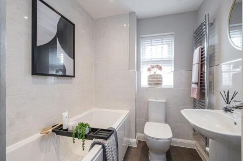 Tiled bathroom with built in bath and a window
