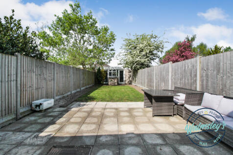 Rear patio &amp; gardens with double garage at far end